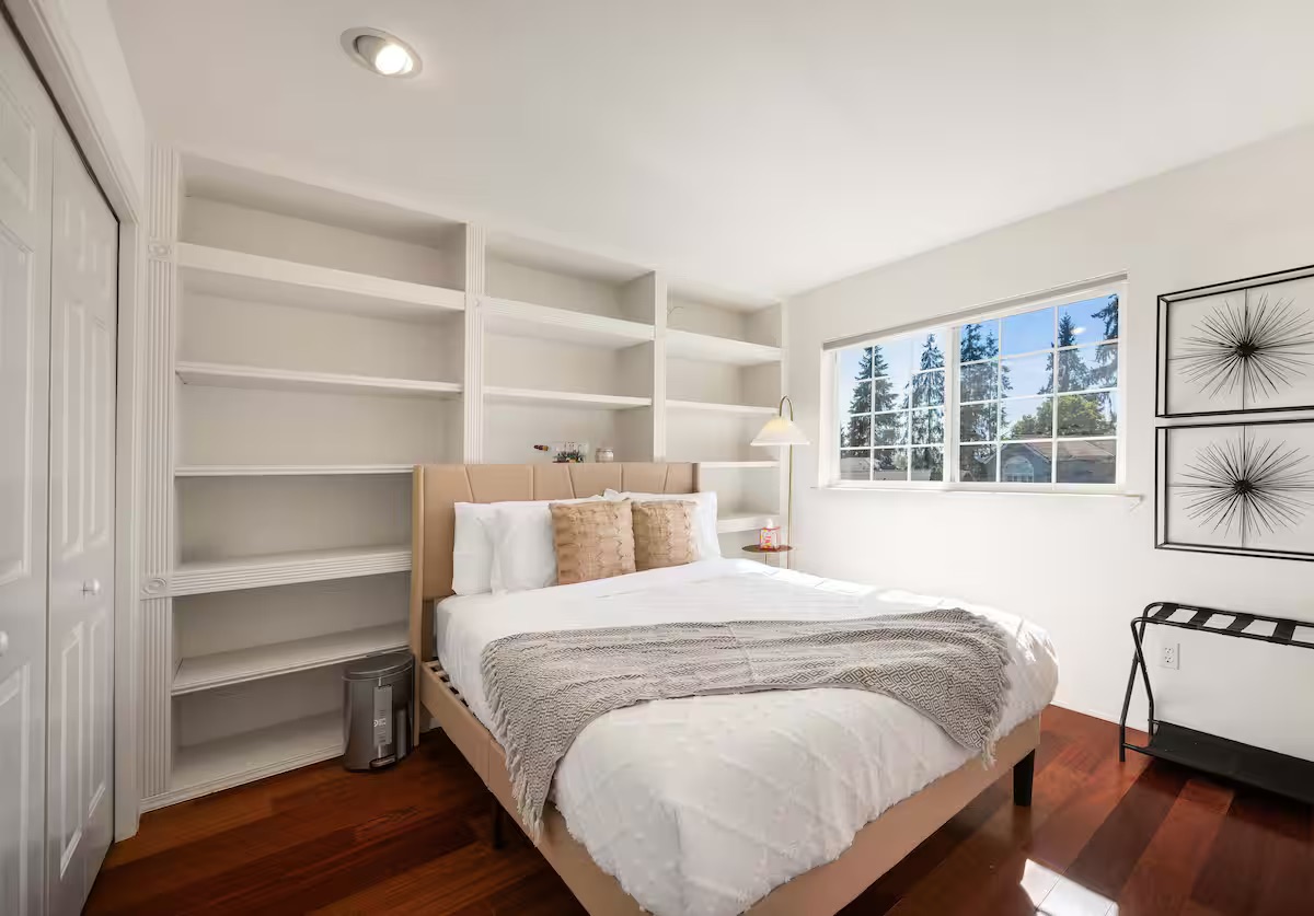 A Kirkland bedroom with a wood headboard and built-in storage.